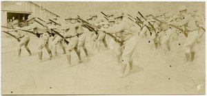 他の人が観察しながら、オープンエリアでライフルの動きを練習する兵士 作： Carl Michel